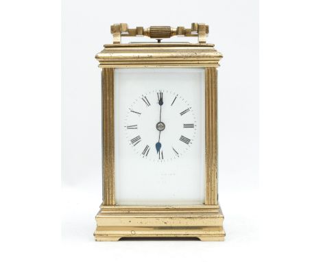 A late 19th century brass striking and repeating carriage clock, white enamel dial with Roman numerals, the movement striking
