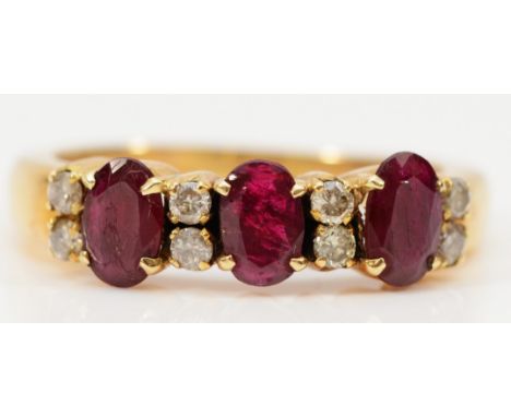 A 14k gold diamond and enhanced ruby ring, three 6mm x 4mm oval enhanced rubys with eight brilliant cut diamonds spread betwe