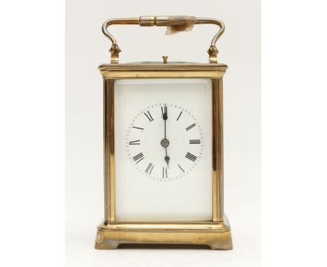 A late 19th century brass striking carriage clock, white enamel dial with Roman numerals, the movement striking the half and 