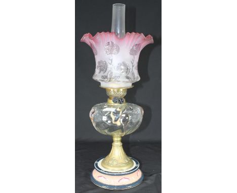 A Victorian Art Nouveau period oil lamp with cranberry coloured shade (possibly replacement), Duplex controls, clear glass re