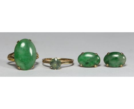 Two yellow metal (test as 14ct gold) rings, one set with a jade coloured, oval cabochon, with a pair of matching earrings, th