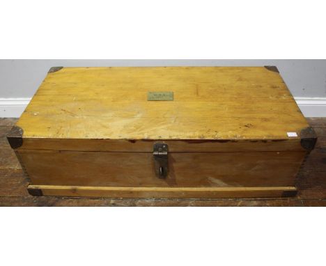 An early 20th century pine trunk of rectangular form, with metal bound corners, handles to each side and brass plaque mounted
