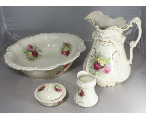 A Victorian pottery wash jug, basin, toothbrush holder and soap dish, decorated with pink and yellow roses to white ground wi