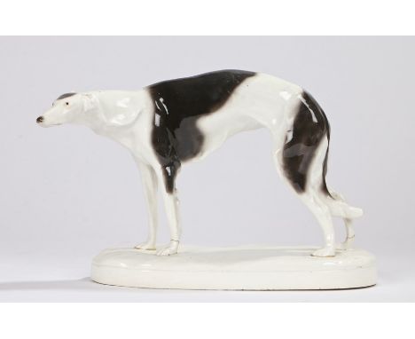 Goldscheider porcelain greyhound, modelled in a standing position, on an oval white plinth base, impressed numbers to base 38