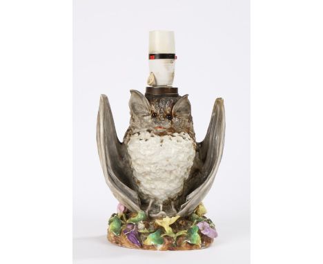 19th Century pottery oil lamp in the form of a bat with wings spread, raised on a floral bocage decorated base, registration 