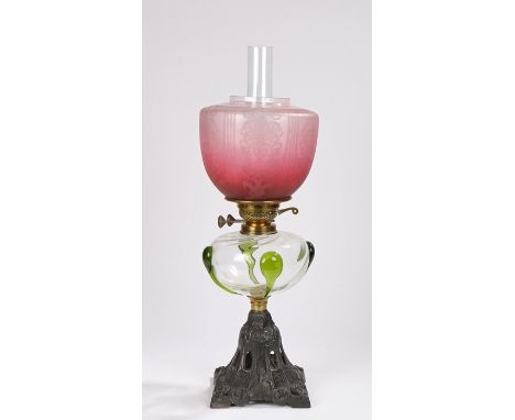 20th Century oil lamp, the frosted puce shade with etched foliate decoration, the clear reservoir with raised green glass dec