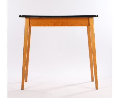 Mid 20th Century kitchen table, the cream melamine top with black edging, raised on light wood tapering legs, the underside o