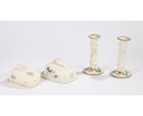 Pair of Poole pottery candlesticks, decorated with roses in the Wemyss style, two Poole pottery butter dishes (4)