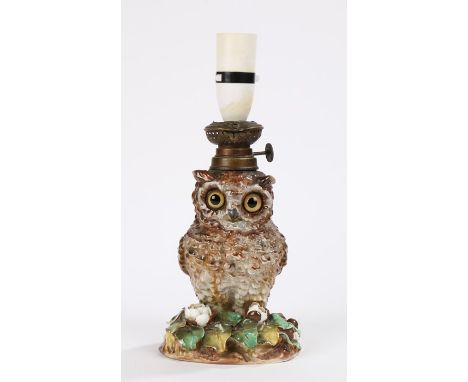 19th Century pottery oil lamp in the form of an owl raised on a floral bocage decorated base, registration mark to base, now 