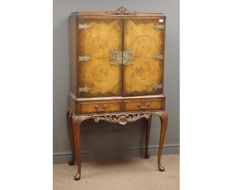 Queen Anne style walnut burr cocktail cabinet,  fleur de lis and scroll carved pediment above two doors with engraved metal h