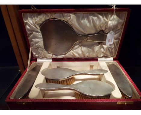 A cased engine engraved Birmingham silver dressing table set comprising of mirror, two hair brushes and two clothes brushes d