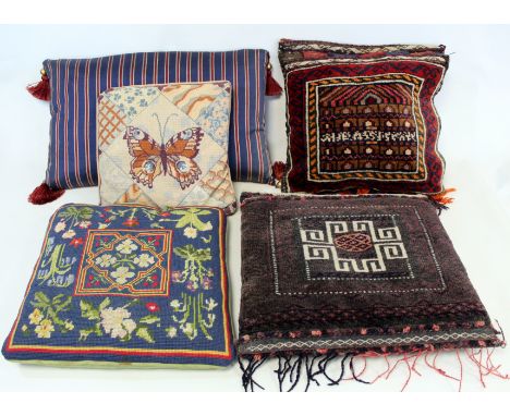 Two wool on cotton woven tribal saddlebag cushions, 42cm x 40cm and 40cm x 38cm; a tasseled rectangular blue, red and grey st