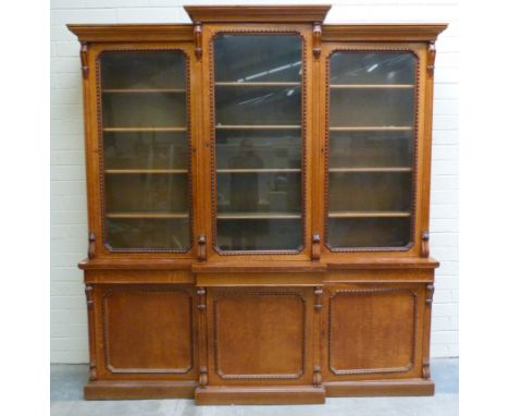 Victorian oak breakfront bookcase, the upper section enclosed by three glazed doors with cupboards below on plinth base. widt