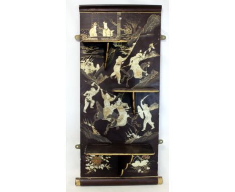 Early 20th century Oriental black and gilt lacquer folding wall shelves, the rectangular back decorated with fighting warrior