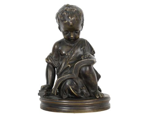 A PATINATED BRONZE SCULPTURE OF A YOUNG BOY READING. 20th century, seated with open book to his lap, his right hand on two bo