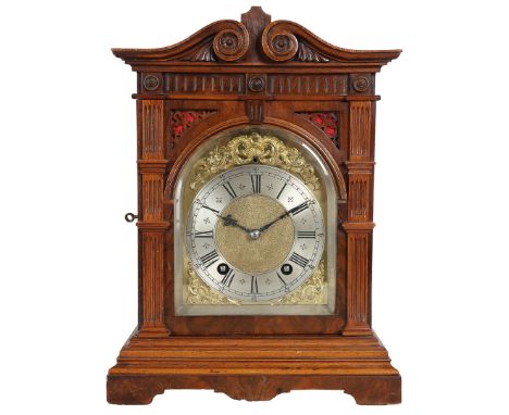 A 19TH CENTURY WALNUT CASED STRIKING MANTLE CLOCK. The walnut case with a scrolled pediment above reeded pilasters on a shape
