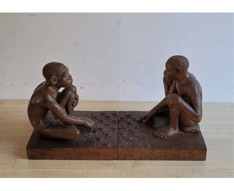 A pair of large African carved hardwood bookends, fashioned as draughts (checkers) players, each approx. 28cm. x 32.5cm at ba