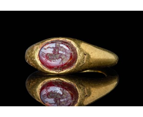 Ca. AD 1 - 200.A gold ring with a D-section round hoop enlarged on the shoulders to form an oval bezel securing a carnelian i