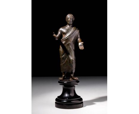 Ca. 400 - 300 BC.A bronze statuette depicting a male votive figure, probably an Aruspix. He is wearing a himation, which is d