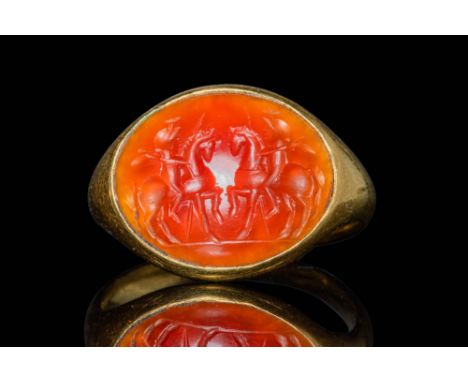 Ca. AD 100 - 300.A gold 21.8 ct ring with a D-section hoop enlarged on the shoulders to form an oval bezel securing a carneli