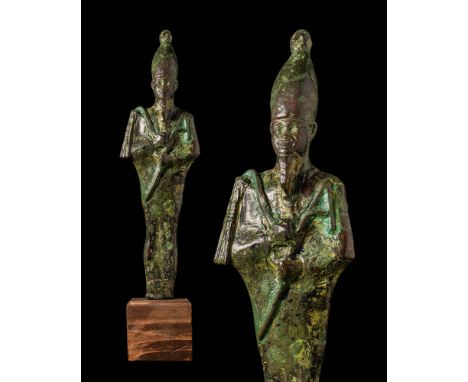 Late Period, ca. 664 - 525 BC.A cast leaded-bronze figure of pharaoh, who holds a crook and flail in arms placed neatly atop 
