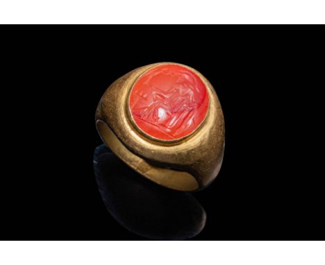 Ca. AD 50 - 200.A stunning 21 ct gold ring composed of a round hoop set with a carnelian intaglio of Minerva. The intaglio sh