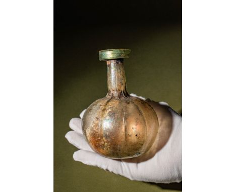 Ca. AD 200 - 300.A glass flask with an onion-shaped body and a concave base. The tubular neck leads to a pronounced rim, whil