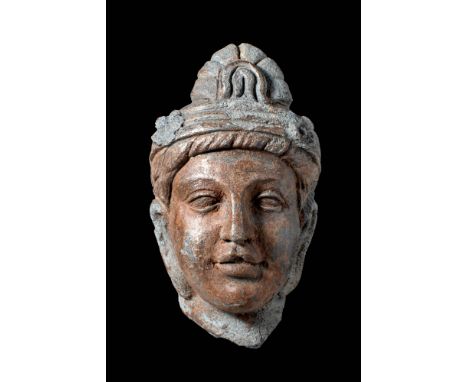 Ca. AD 200 - 300.A schist head of a Bodhisattva with a serene expression, characterised by heavy-lidded eyes and an intricate