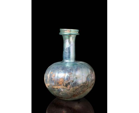 Ca. AD 300 - 400.A pale blue and green glass bottle with an apple-shaped body and a concave base. It has a long cylindrical n