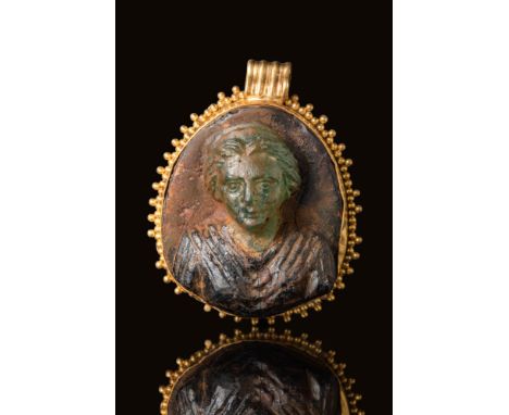Ca. AD 300 BC.An oval-shaped gold pendant with a frame decorated by small, closely spaced spheres along its perimeter. A ribb