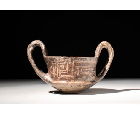 Ca. 700 BC.A ceramic kantharos, a deep vessel with distinctive high openwork twisted handles, meant for consuming wine. This 