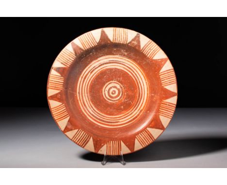 Ca. 1050 - 900 BC.A beautiful, wheel-thrown pottery dish of shallow, circular, white-ground form decorated with ample motifs 