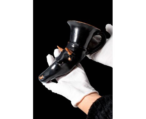 Ca. 400 - 300 BC.A pottery rhyton covered in black glaze, formed in the shape of a bull's head. The prominent head displays a