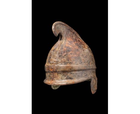 Ca. 400 - 300 BC.An iron Phrygian helmet with a distinctive conical body and a curved terminus, a flat protruding rim, pierce
