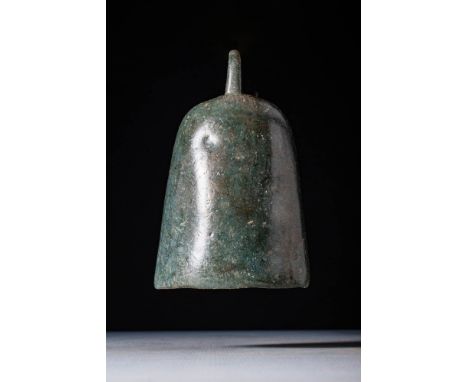 Ca. AD 100 - 300.An elongated bronze bell with vertical walls, showing a smooth green patina. Inside, the iron knocker is sti
