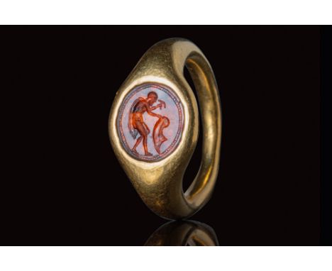 Ca. 300 - 200 BC.A gold ring with a D-section hoop that enlarges at the shoulders to form a bezel, securing a circular carnel