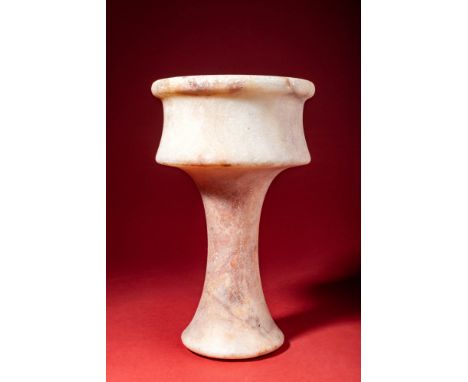 Ca. 3000 - 2000 BC.An alabaster chalice with a tall stem on a conical foot, the cylindrical bowl tapering slightly towards th