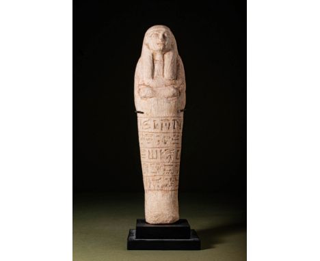 New Kingdom, Ca. 1550 - 1069 BC.A carved limestone ushabti figure standing in mummiform with fused legs and feet protruding f