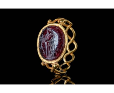 Ca. AD 300.A gold ring with an openwork design. Its round hoop consists of two coiled gold threads connected to an oval bezel