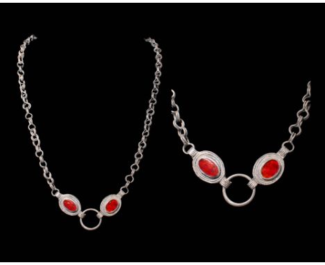 Ca. AD 400 - 600.A necklace composed of a silver loop-in-loop chain. Suspended from the chain are two oval-shaped reddish-ora
