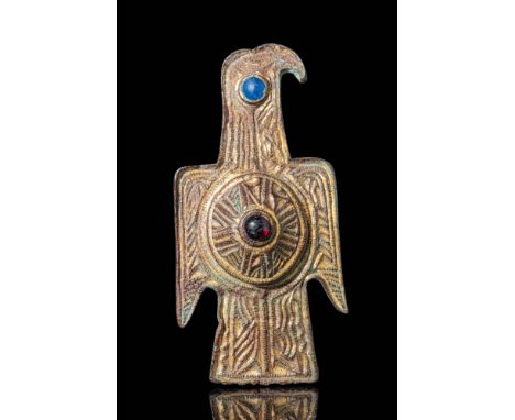 Ca. AD 400 - 500.A large gold-gilt bronze eagle-shaped fibula with open wings and a straight head. In the centre of its body,