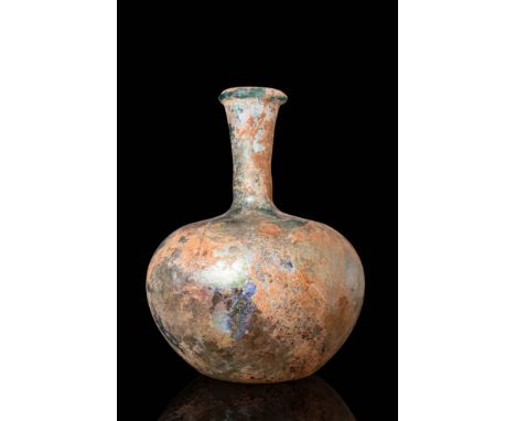 Ca. AD 100 - 300.A glass flask with an apple-shaped lower body and a concave base. It has a prominent rounded shoulder, a fun