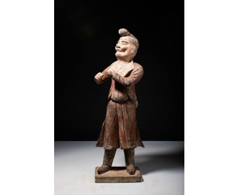 Ca. AD 619 - 906.A standing terracotta foreigner. Dressed in foreigner riding attire, the figure appears to be in motion with