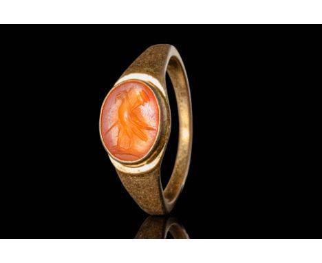 Ca. AD 100 - 300. A Roman carved carnelian intaglio with translucent orange hues, presenting a single eagle facing right, wit