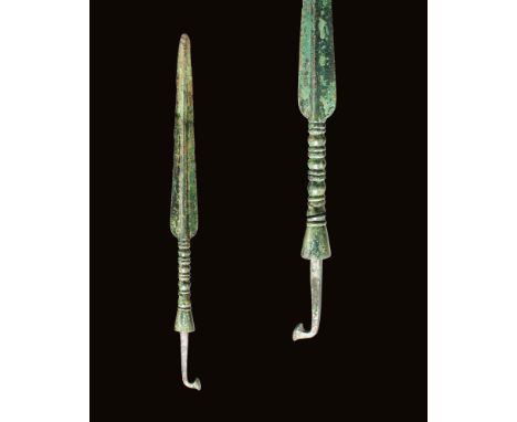 Ca. 1200 - 800 BC.A long bronze spearhead from the Near East features two sharp edges that taper towards a pointed tip, surro