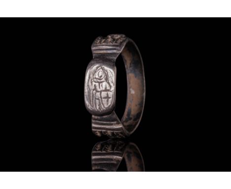 Ca. AD 1100 - 1300.A silver ring with a round hoop with polygonal sections, adorned on the shoulders with relief shields deco