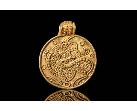 Ca. AD 800 - 1100.A pendant of discoid form, shaped from a thin sheet of gold, features planar faces and a slender peripheral