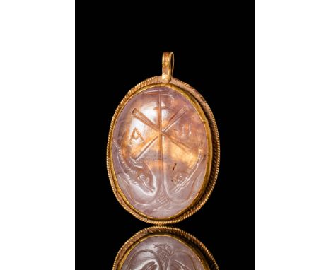 Ca. AD 350 - 500. A rare Byzantine gold pendant with rope shaped decoration securing an amethyst intaglio of oval shape, engr