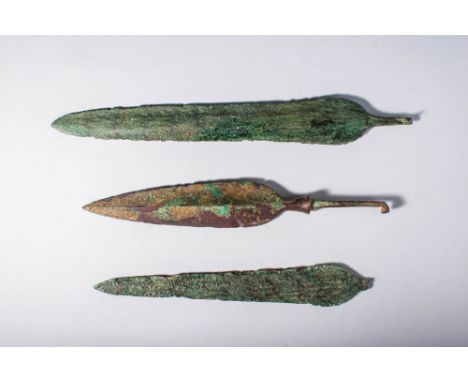 Ca. 1200 - 600 BC.A collection of three bronze weapons. The first item is a short dagger, crafted using the lost wax (cire pe