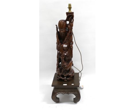Chinese carved floor lamp in the form of an immortal on a square stand with shaped supports, 100cm high approximately